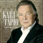 Kari Tapion "Kaksi maailmaa" -albumin kansikuva, jossa artistin potretti oikeassa laidassa kuvioitua taustaa vasten. Kari Tapion ja albumin nimi miehen vasemmalla puolella. Tapiolla musta puku ja valkoinen kauluspaita, ei solmiota.