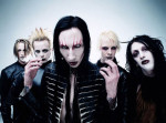 Viisi Marilyn Manson -yhtyeen jäsentä seisoo vaaleansinistä taustaa vasten. Keskimmäisenä bändin keulahahmo. Kaikilla miehistä naamat meikin peitossa. Heillä synkät ilmeet kasvoillaan.