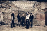 Viisihenkisen Nightwish-bändin jäsenet seisovat raunioituneen kiviseinämän tai muurin edustalla yhtenä rykelmänä. Miehet pukeutuneet mustiin, naisella pitkät mustat hiukset ja valkoinen paita sekä mustat housut.