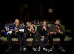 Coldplayn promovalokuva, jossa nelihenkinen miehistö istuu tummaa taustaa vasten rivissä vaalealla sohvalla tai penkkirivstöllä. Vasemmanpuoleisella miehellä kitara tai basso sylissä. Kolme oikeanpuoleista jamppaa katselee kieroon ylöspäin.