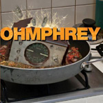 Ohmphreyn albumin "Ohmphrey" etukannessa valokuva paistoastiasta hellalla. Astiassa on jonkinlainen metallinen laatikko keskellä vihanneksia ja kasviksia, jotka muhivat astian alaosassa. Keskellä kuvaa päällimmäisenä kellertävällä värityksellä yhtyeen nim