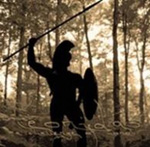 A Challenge of Honourin albumin "Leonidas" etukannessa valokuva soturista, jolla spartalainen kypärä, keihäs ja kilpi. Miehen hahmo on musta siluetti metsäistä taustaa vasten.